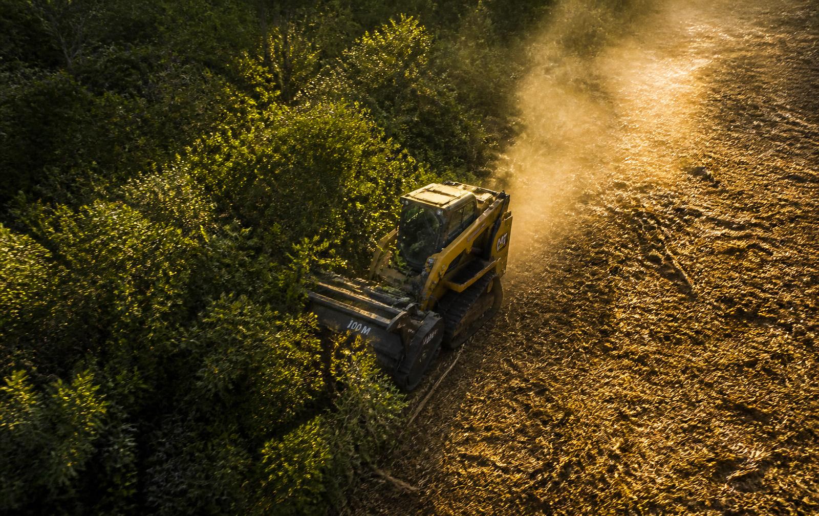 Aerial view of a forestry mulcher cutting a clean path through dense Indiana woodland